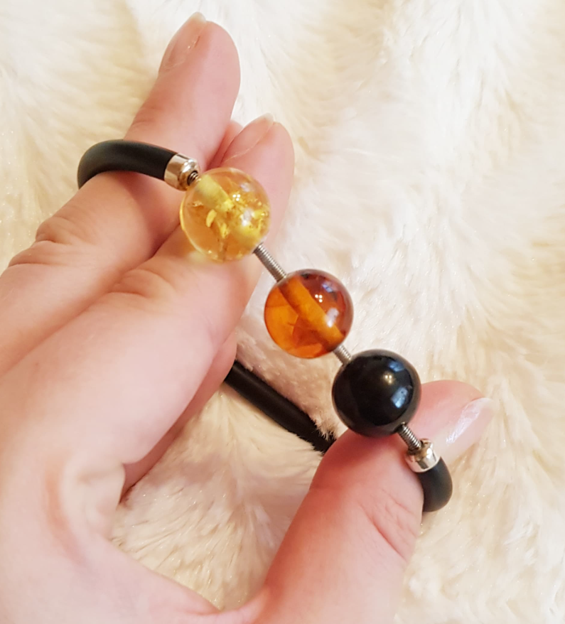 A beautiful adjustable bracelet with a built-in spring with Baltic amber balls in three colors