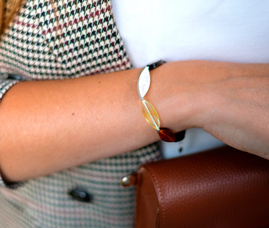 A bracelet made of amber in three colors and silver in the shape of leaves.