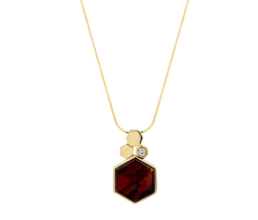 An elegant cherry amber pendant on a long chain with a shiny zircon