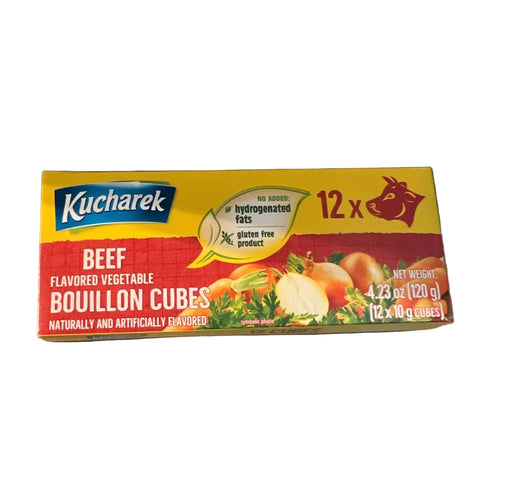 A box of Kucharek Beef Flavored Vegetable Bouillon Cubes on a stainless steel surface. The packaging is yellow, red, and blue, with illustrations of beef and vegetables, and text indicating 12 x 10g cubes.