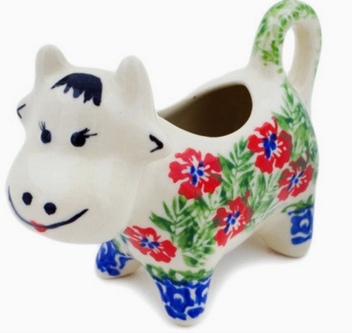 Ceramic cow planter with floral design on a white background