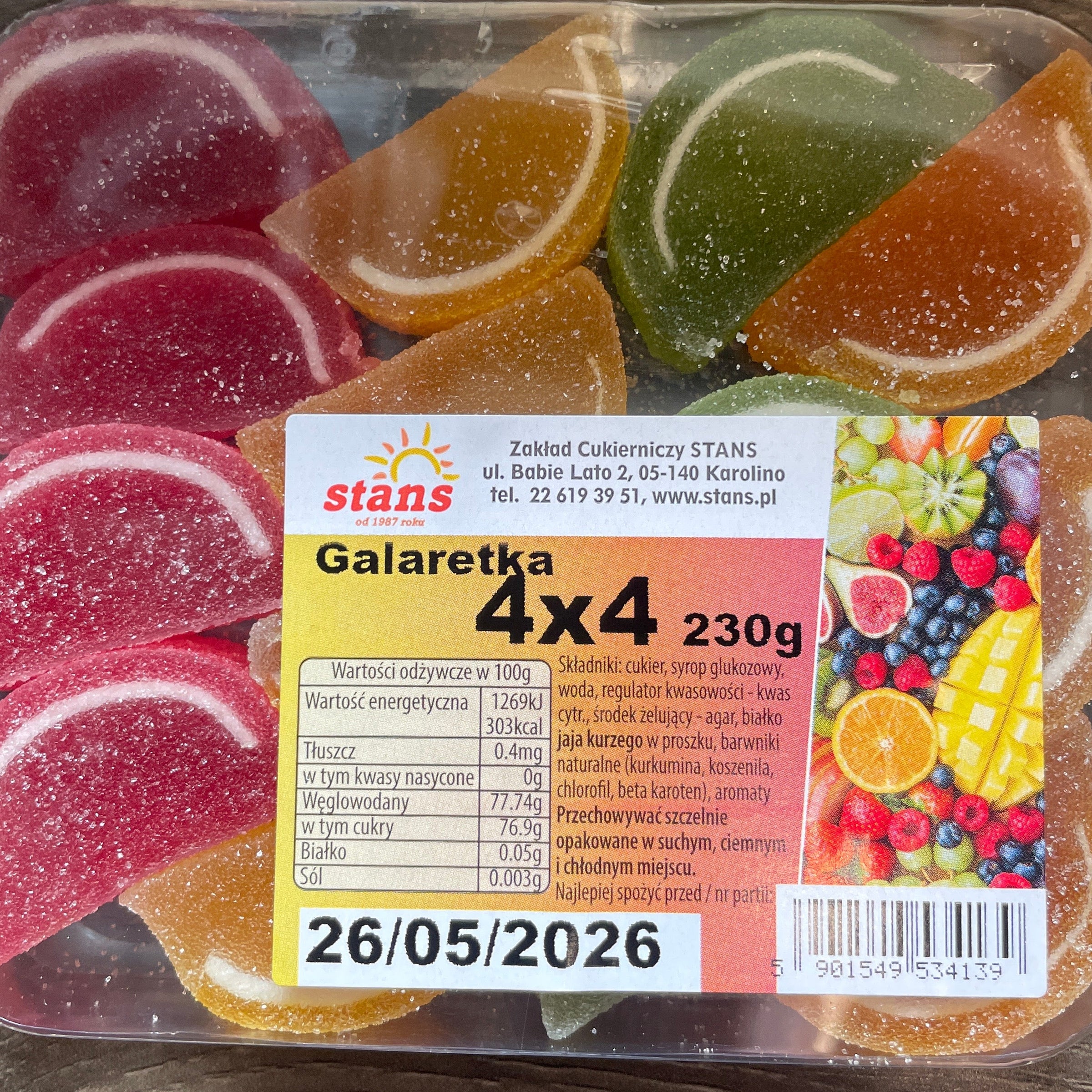 Packaged fruit-flavored gummy candies with a label on a wooden surface