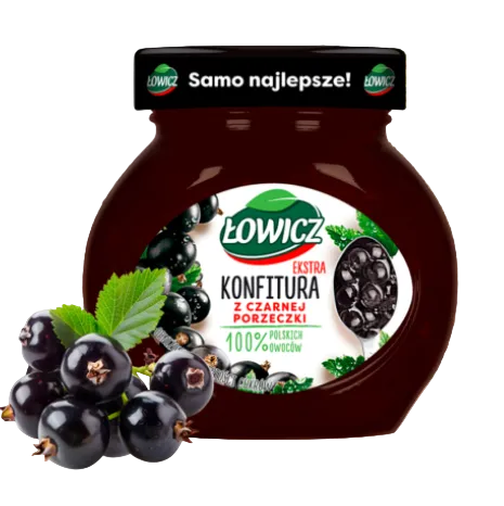 Jar of black currant jam with a label on a wooden surface and blurred greenery background