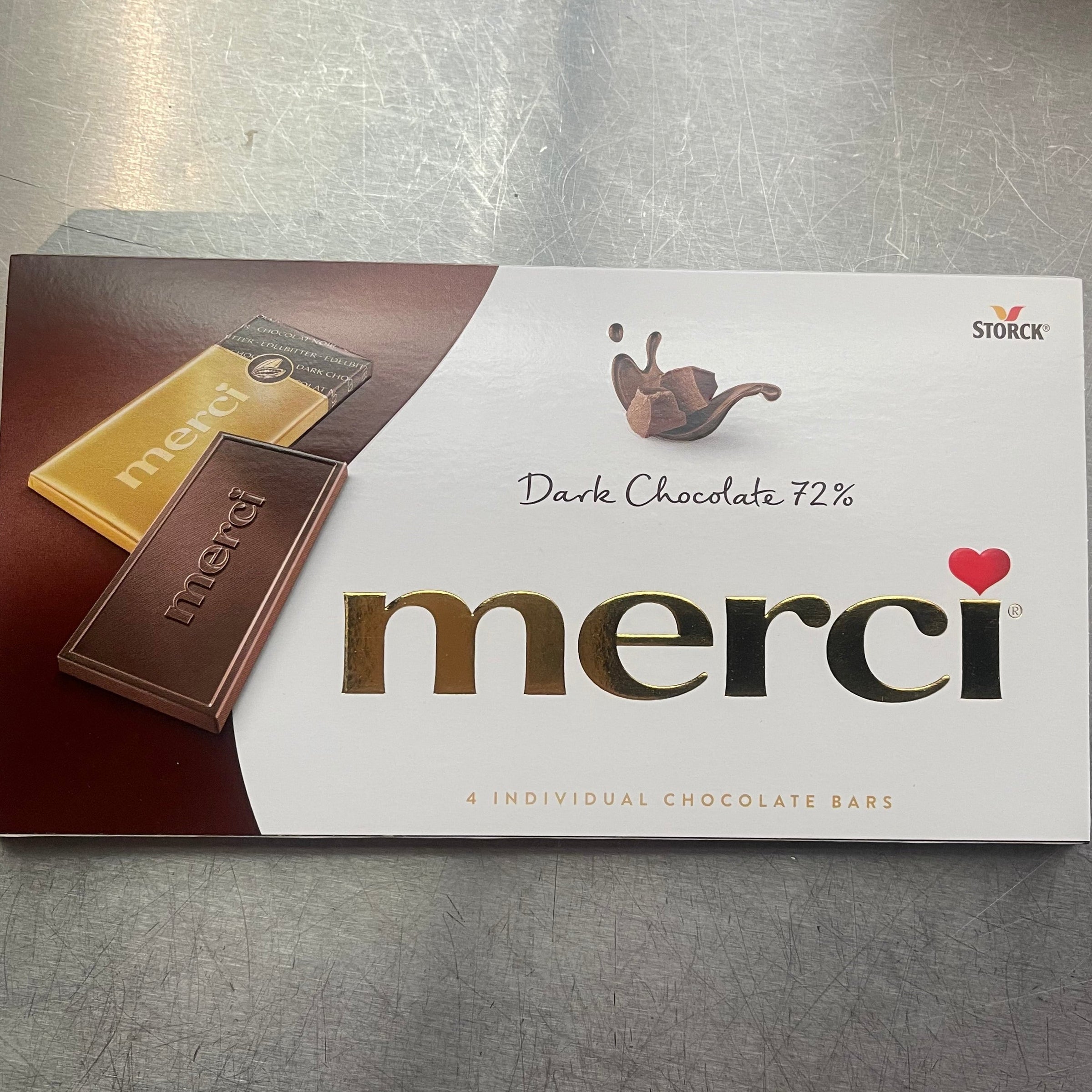 Merci chocolate bar packaging on a metallic surface