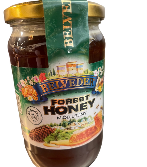 Jar of Belveder Forest Honey on a gray surface with a blurred background