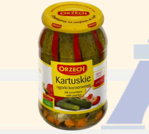 Jar of Orzech pickled cucumbers with a yellow lid on a light background
