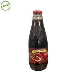 Bottle of organic pomegranate juice with a red cap on a white background