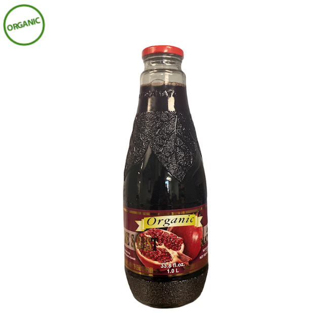 Bottle of organic pomegranate juice with a red cap on a white background