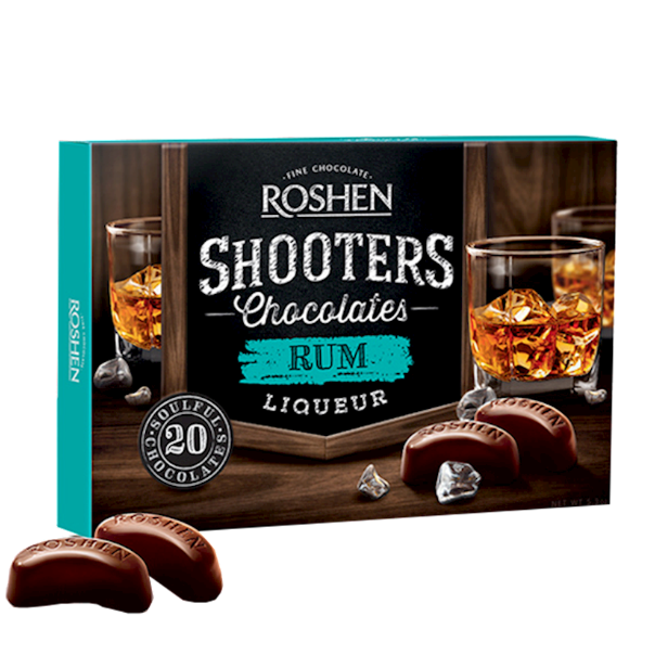 Box of Roshen Shooters Chocolates Rum Liqueur with chocolate shots on a wooden surface.