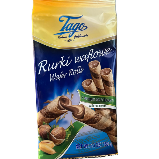 A package of Tago Wafer Rolls with nut cream, featuring a yellow-to-blue gradient bag with illustrations of chocolate-covered wafer rolls and hazelnuts, standing on a metallic surface.