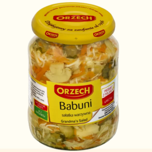 Jar of Orzech Babuni salad with a yellow lid on a white background
