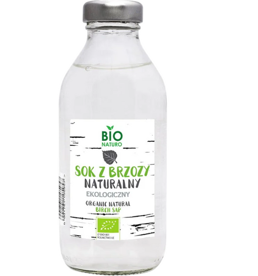 Clear glass bottle of organic natural birch sap with a label on a white background