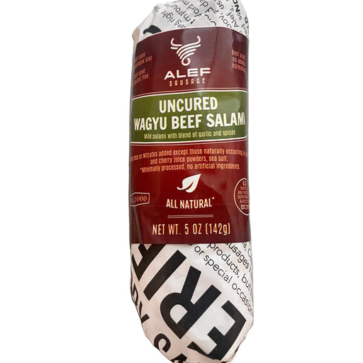 Rolled salami with a label on a metallic surface