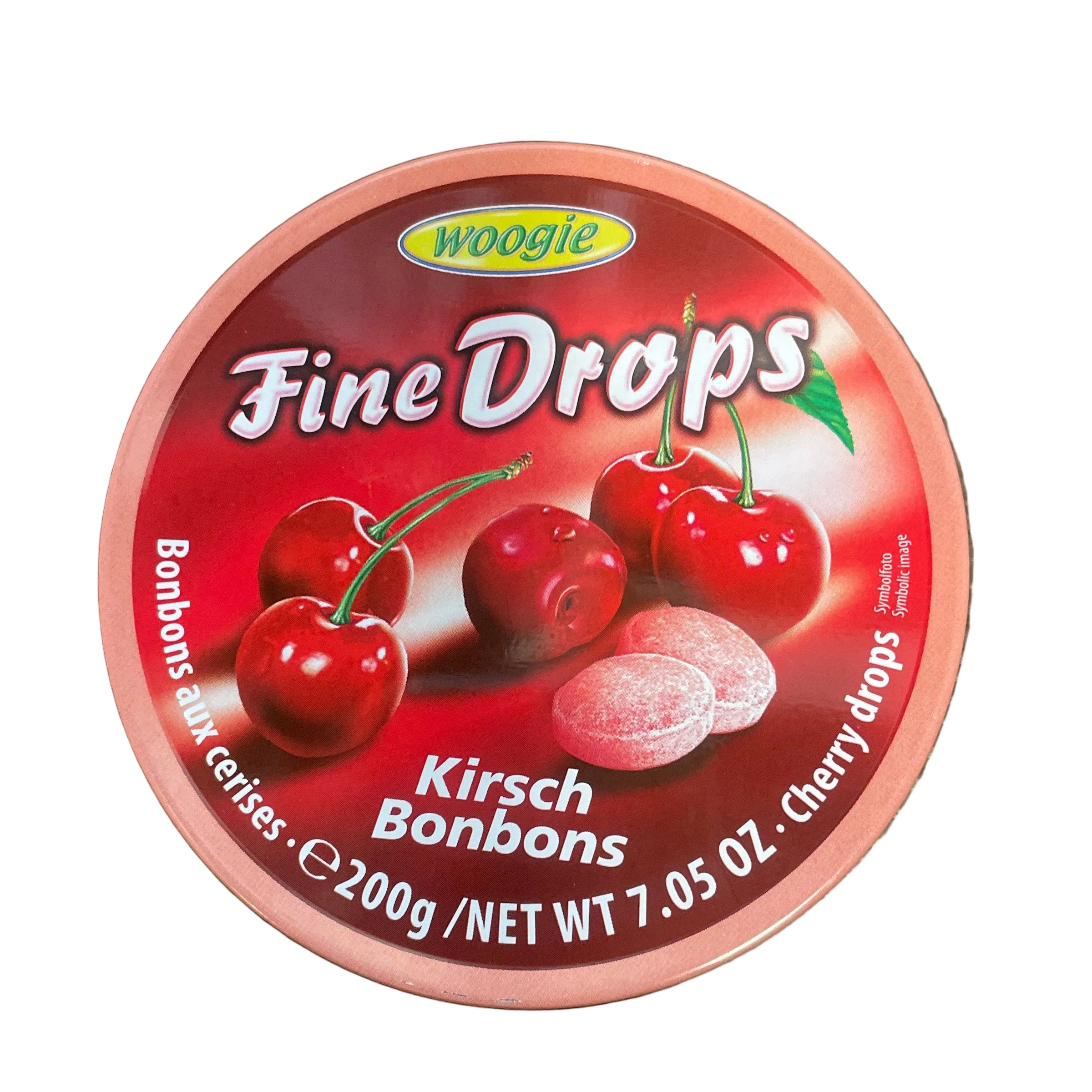 A round container of Wooble Fine Drops cherry candies on a dark wood-grain surface. The packaging features a red and pink design with illustrations of fresh cherries and white candy pieces.
