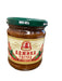 Jar of ajika with a label on a wooden surface