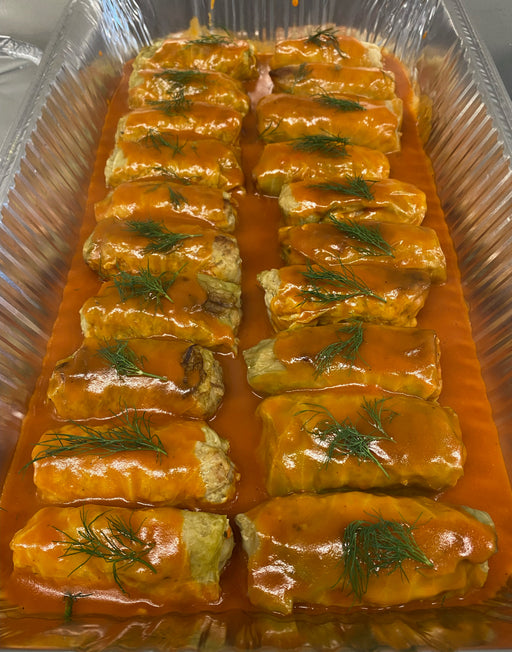 Cabbage rolls in tomato sauce in a aluminum deli tray